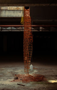 Illuminated chandelier hanging on wall in abandoned building