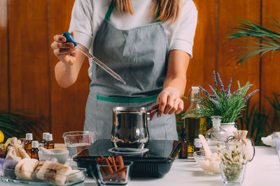 Midsection of woman having food at table