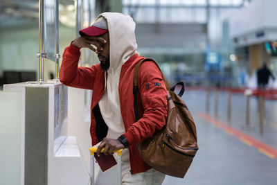 Frustrated disappointed african american male passenger with luggage overslept and missed flight