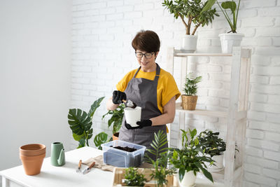 Side view of woman holding christmas tree at home