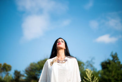 Low angle view of woman standing against sky