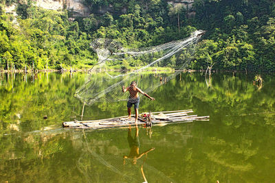 Man standing by lake against trees