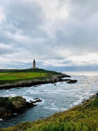 Lighthouse by sea against sky