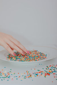 Close-up of hand on table against white background