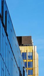 Low angle view of modern building against clear blue sky