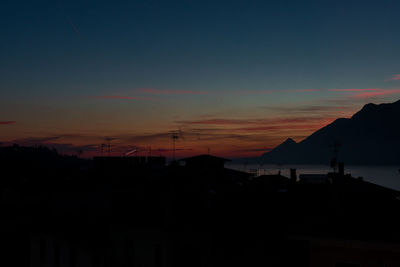 Silhouette buildings against sky at sunset