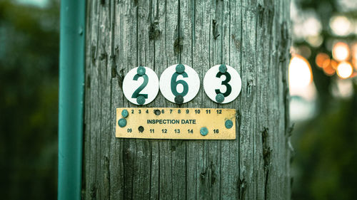 Close-up of information sign on wooden post