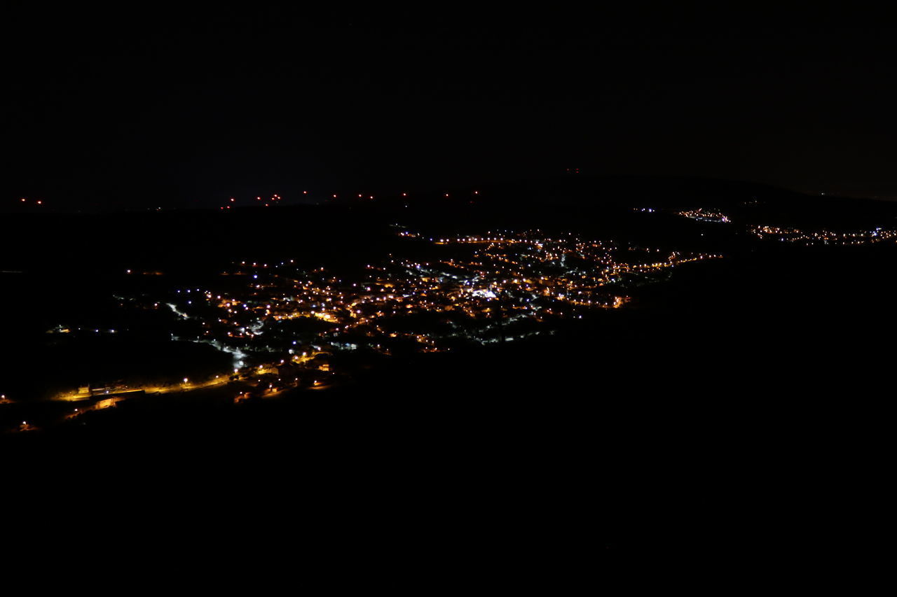 HIGH ANGLE VIEW OF ILLUMINATED BUILDINGS AGAINST SKY AT NIGHT