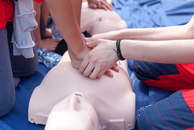 Volunteers giving first aid training with mannequin