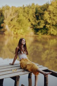 Young woman sitting on railing