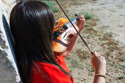 Woman playing violin on footpath