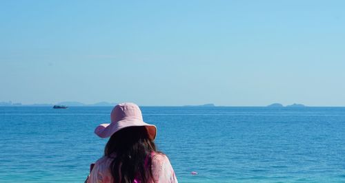 Rear view of woman in sea against clear sky