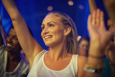 Smiling woman dancing at musical concert