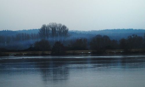 Scenic view of lake against sky during winter