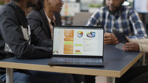 Chart diagrams on laptop at table in office