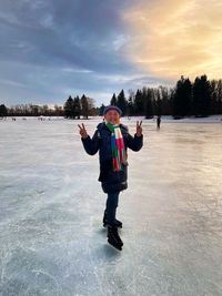 Full length of man standing on snow with ice skates