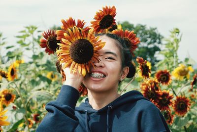 Portrait of smiling woman with sunflower