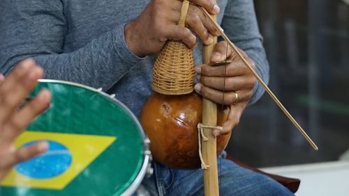 Midsection of man playing traditional musical instrument