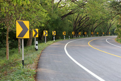 Road sign by trees in city