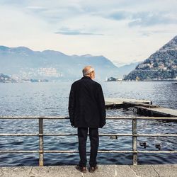 Man standing on cliff by sea