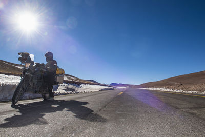 Woman standing next to her touring motorbike close to paso de jama