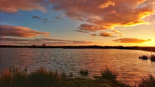 Scenic view of lake against sky during sunset