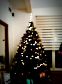 Defocused image of illuminated christmas tree at home