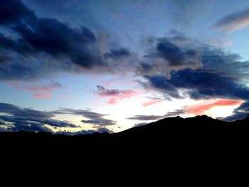 Scenic view of silhouette mountains against dramatic sky