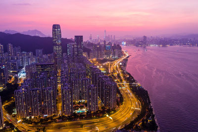 High angle view of city lit up at sunset