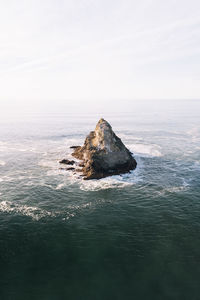 Mountain in sea against sky