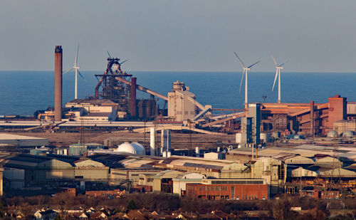 High angle view of buildings by sea against sky