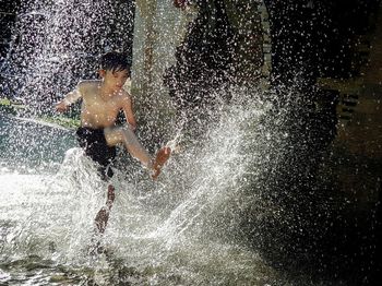 Man splashing water in swimming pool