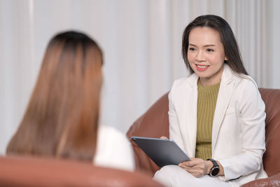 Portrait of a smiling young woman using smart phone