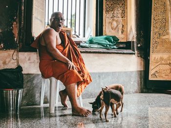 Man and dog by window on building