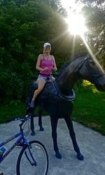 Full length of woman riding bicycle on plants