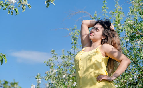 Side view of woman standing against trees