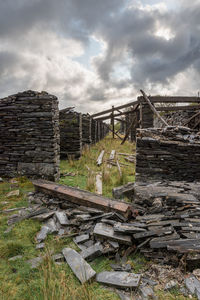 Old wooden structure on field against sky