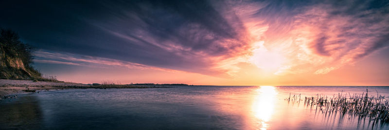 Scenic view of sea against romantic sky at sunset