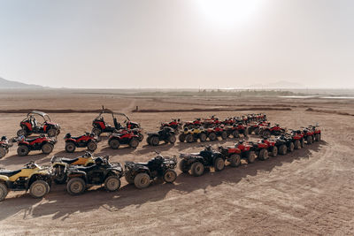 Group of people in row on desert against sky