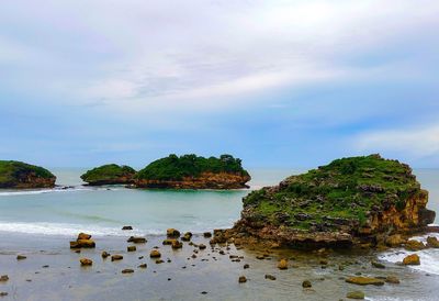 Rocks on beach against sky