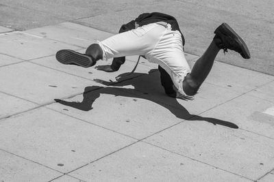 Rear view of man breakdancing on floor
