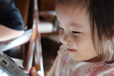 Close-up portrait of cute girl using mobile phone