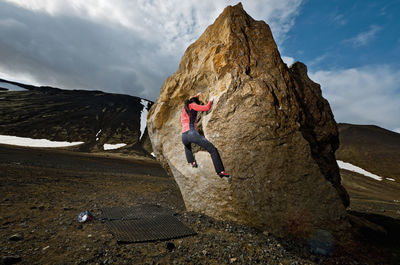 Woman bouldering on rock in rural iceland