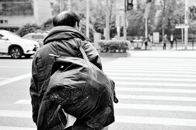 Rear view of woman with umbrella walking on road