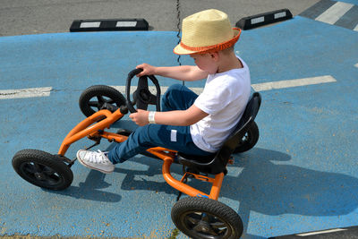 Boy driving quad bike, four wheel cycle car, spring brightly morning, sunny day