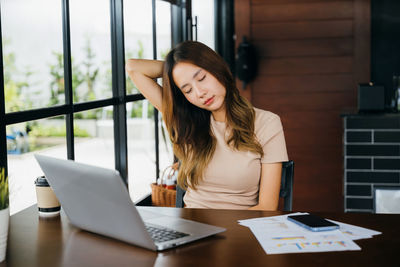 Young woman using laptop at table