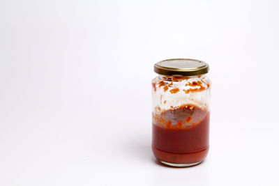 Close-up of glass of jar against white background