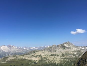 Scenic view of mountains against blue sky