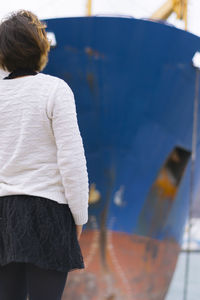 Young girl looking the blue boat prow