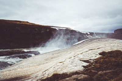 Scenic view of waterfall against sky